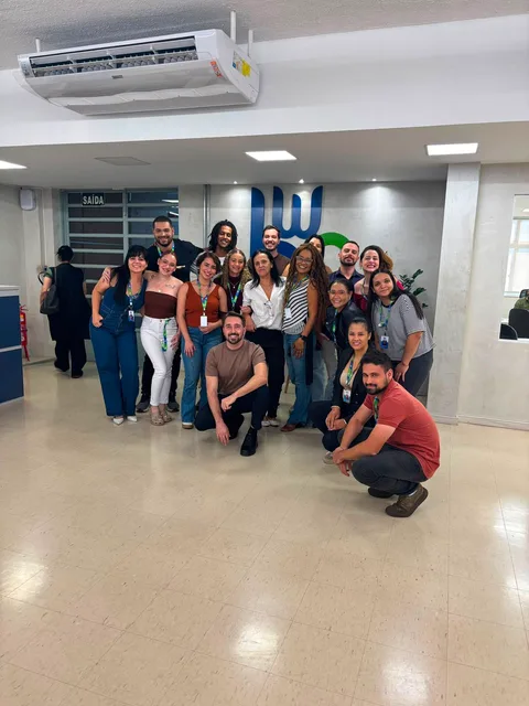 Time da operação posando com a equipe do cliente no escritório